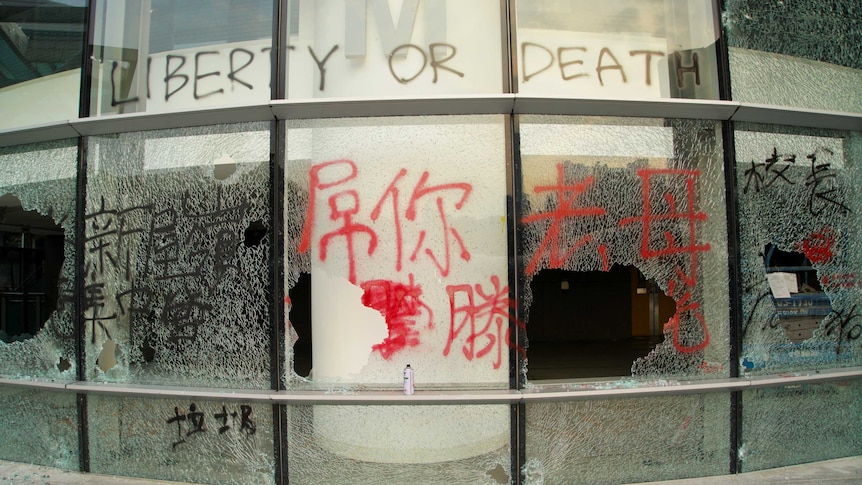 Windows are smashed, while others are tagged with graffiti reading "LIBERTY OR DEATH" during the Hong Kong protests.