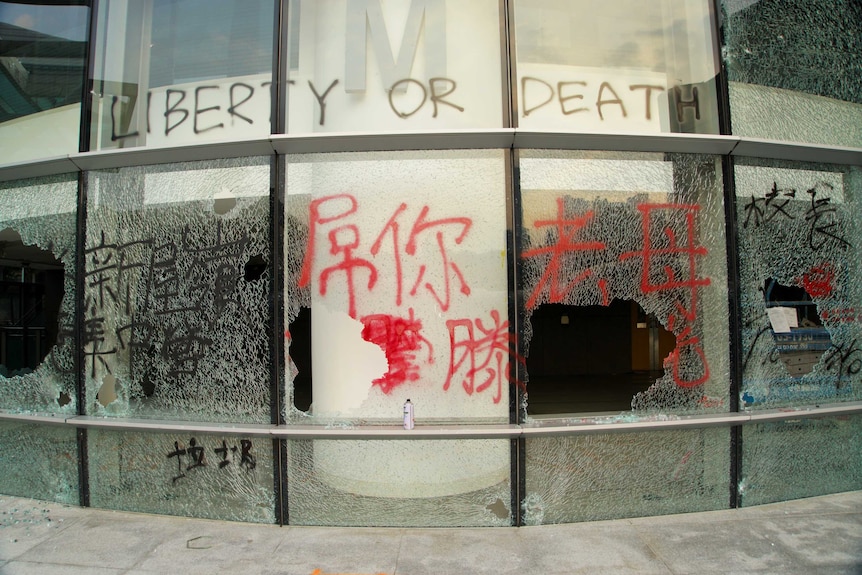 Windows are smashed, while others are tagged with graffiti reading "LIBERTY OR DEATH" during the Hong Kong protests.