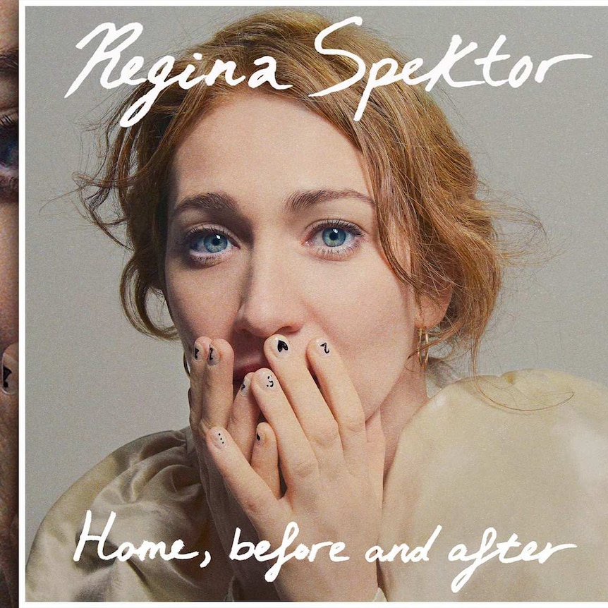 Regina Spektor has her hands over her mouth. Her fingernails are painted with numbers, hearts, dots