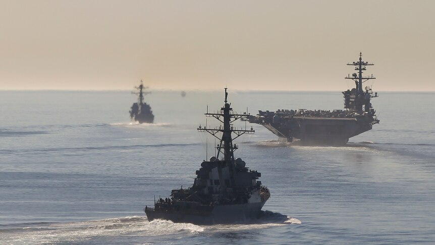 Several US Navy vessels sail through the Pacific