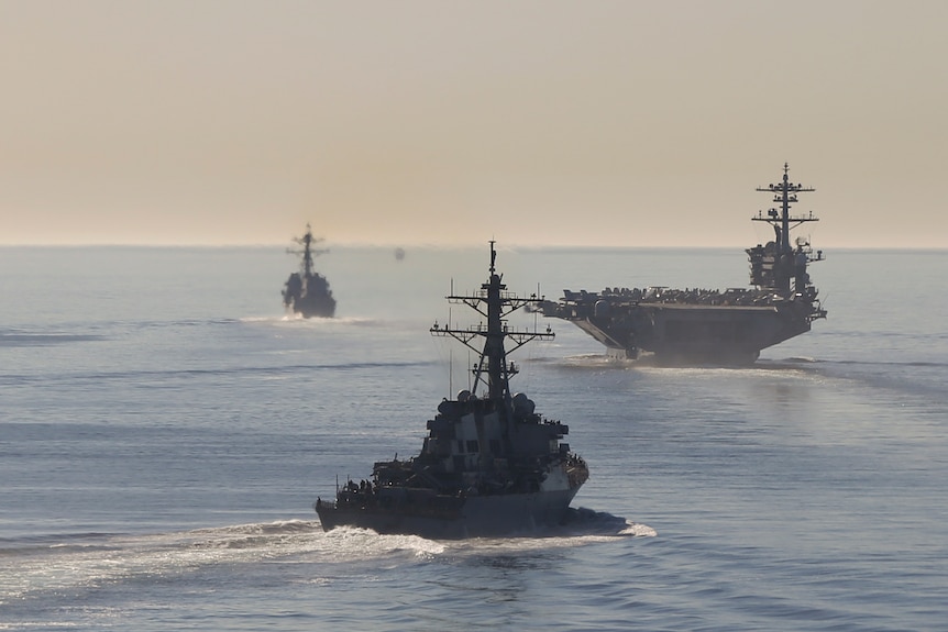 Several US Navy vessels sail through the Pacific