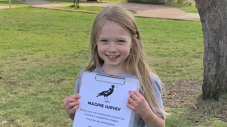 Smiling young girl holds clipboard with paper saying magpie survey