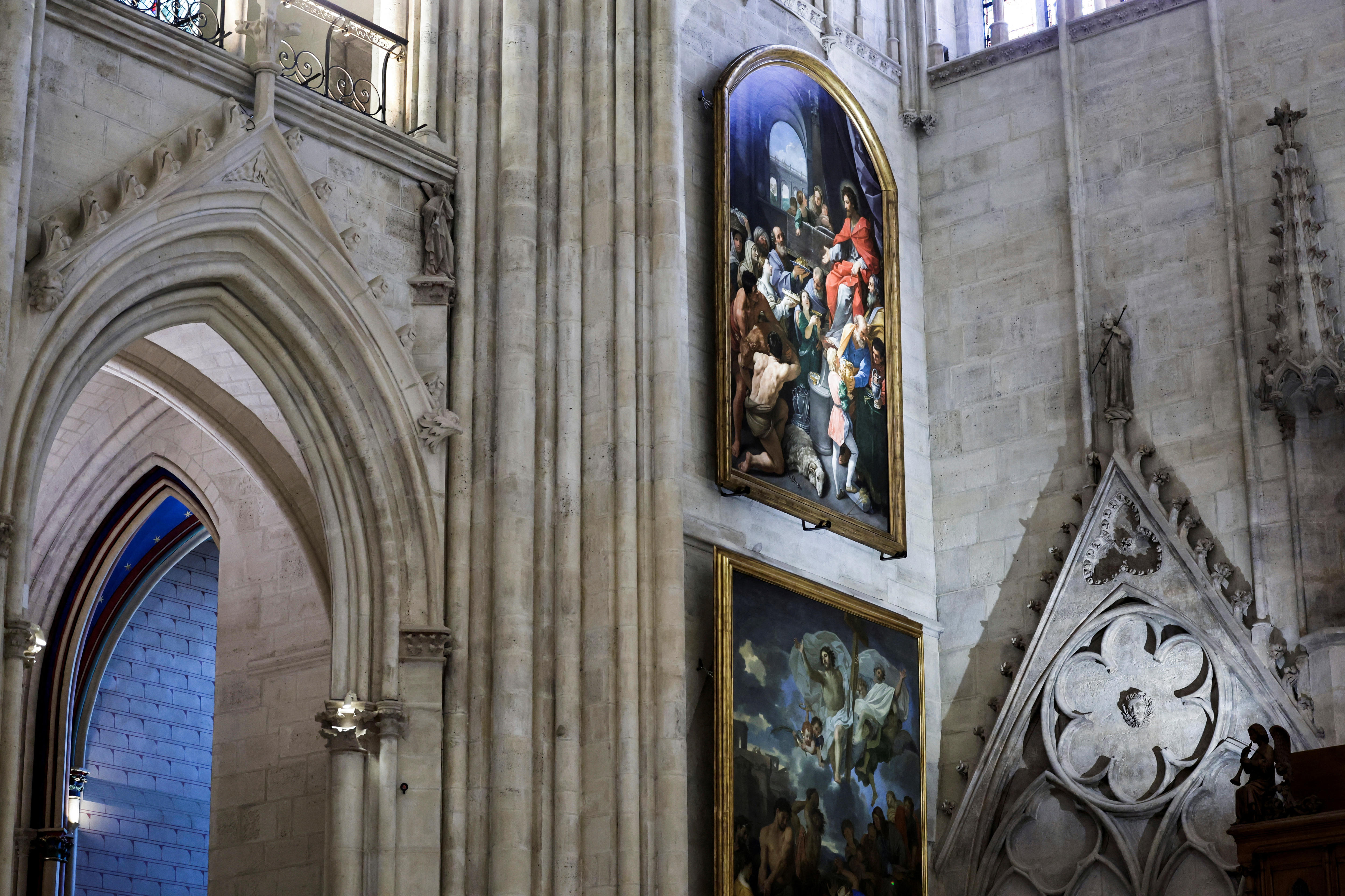 Paintings on the wall of a white marble church closer up with a doorway visible to the left