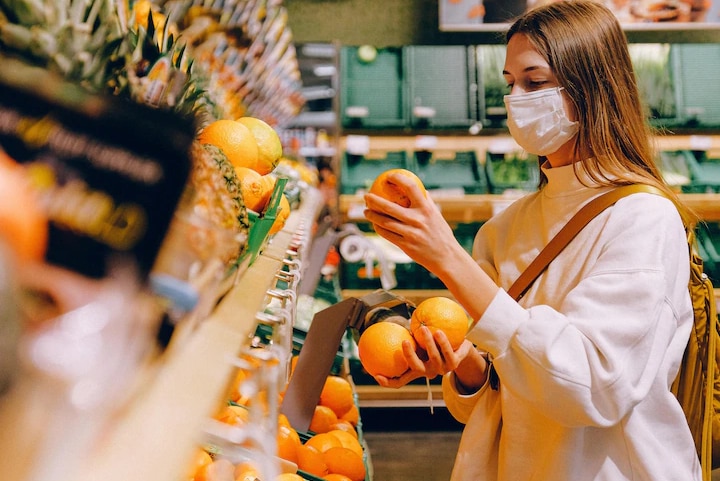 Жінка збирає фрукти в супермаркеті.
