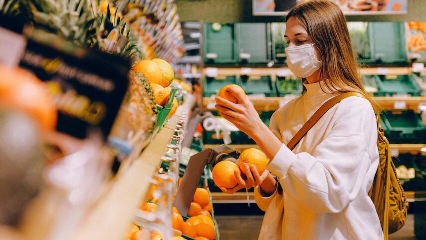 A woman is choosing fruits at supermarket.