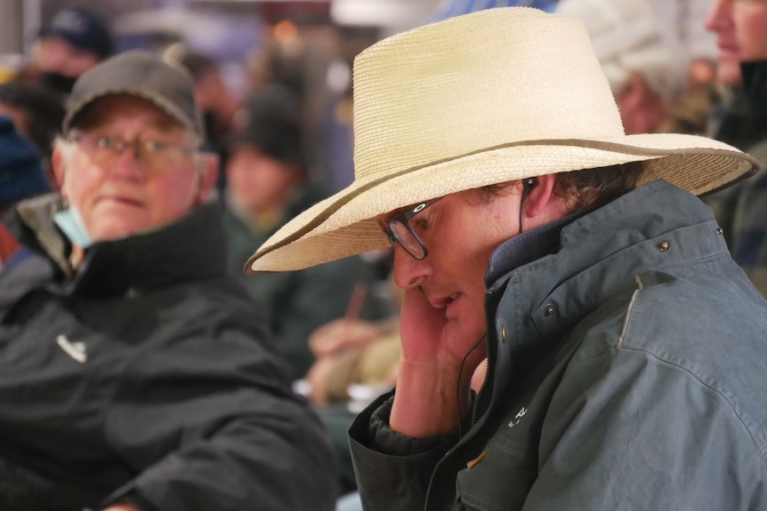 A man monitors for online bids during the auction.