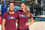 Caitlin Bettenay and Georgia Johnson stand near a volleyball net.