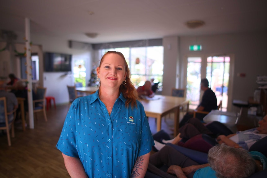 Jade Murray standing in room with unidentified elderly residents in background