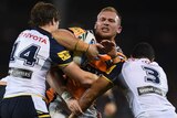 Matthew Lodge of the Tigers is tackled by the Cowboys' Rory Kostjasyn (L) and Justin O'Neil in 2015.