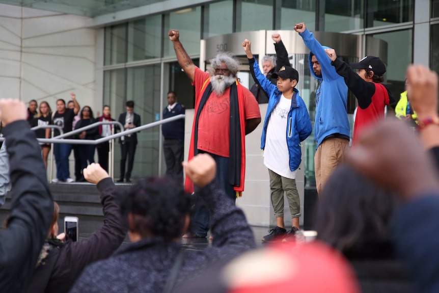 Protesters with their fists in the air outside the Supreme Court in Perth.