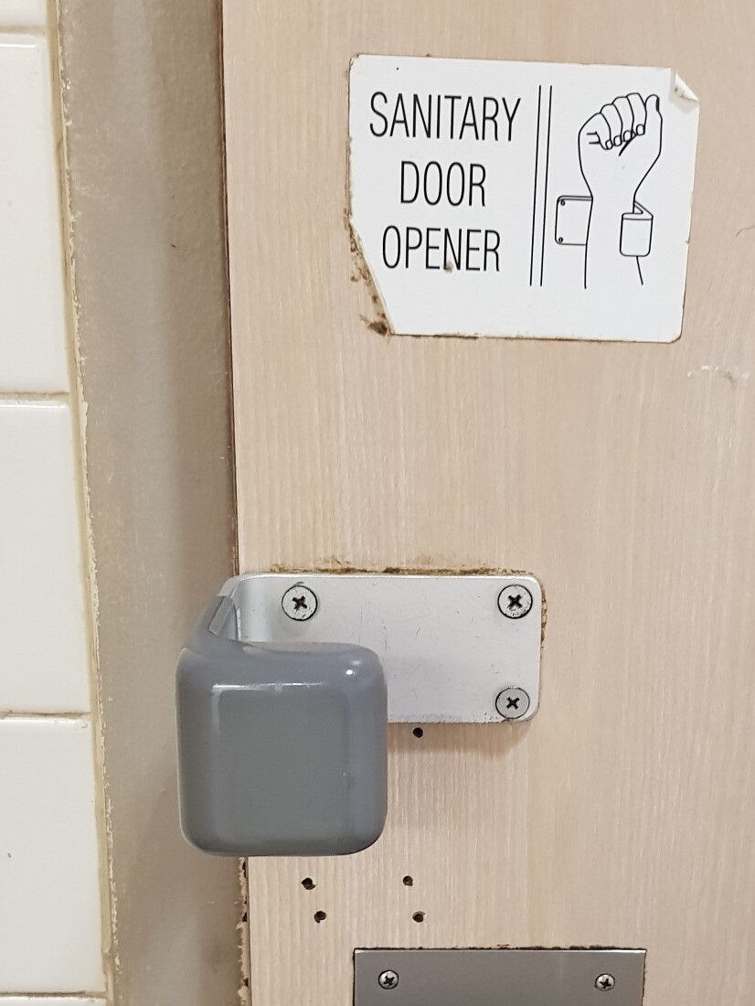 Handle on toilet that allows people to open the door without using their hands
