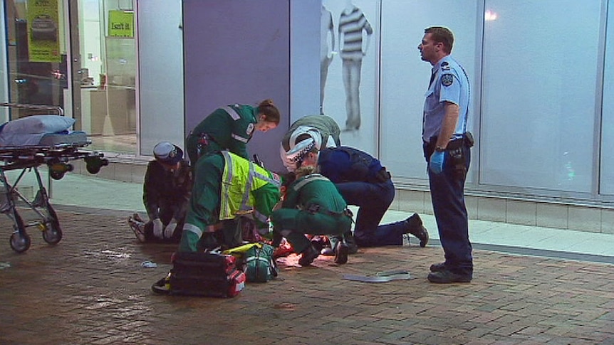 Police and paramedics attend the scene of the fatal stabbing.