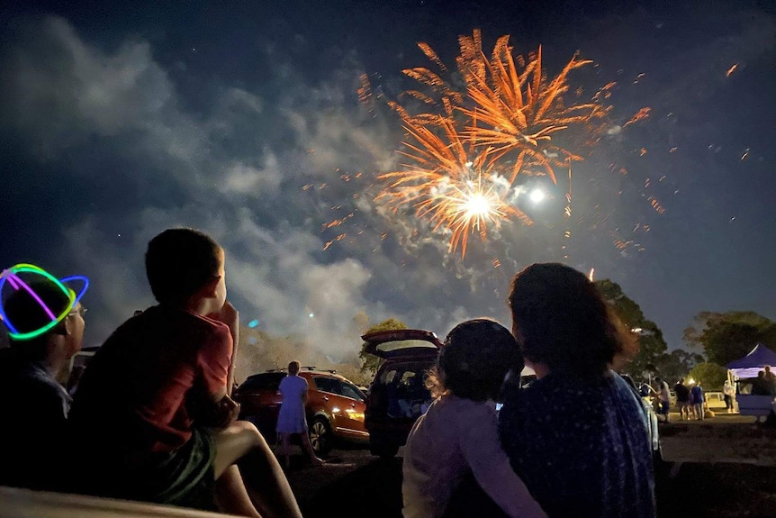 Families watch the fireworks from a drive-in theatre at Ipswich.