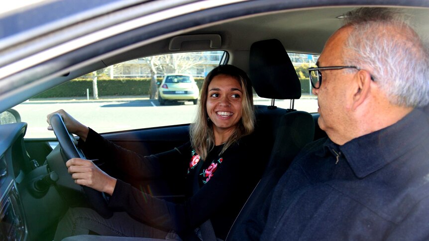 Karteorah McBride sitting in a car with her driving instructor Greg Narrier.