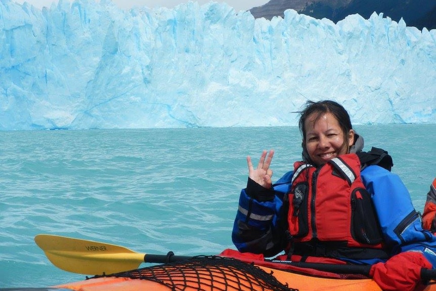 Zara Tai kayaking in the ocean, with Argentina's Perito Moreno glacier in background.