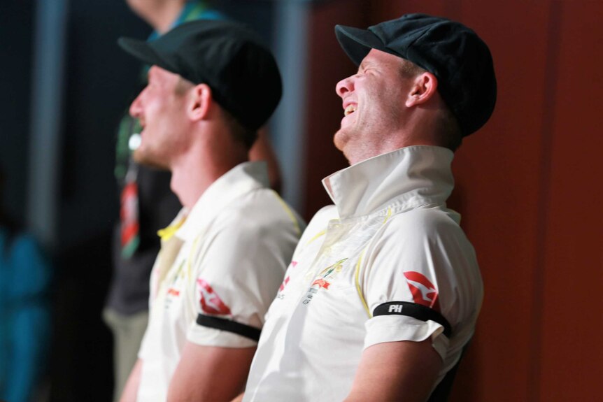 Steve Smith laughs, with Cameron Bancroft in the background.