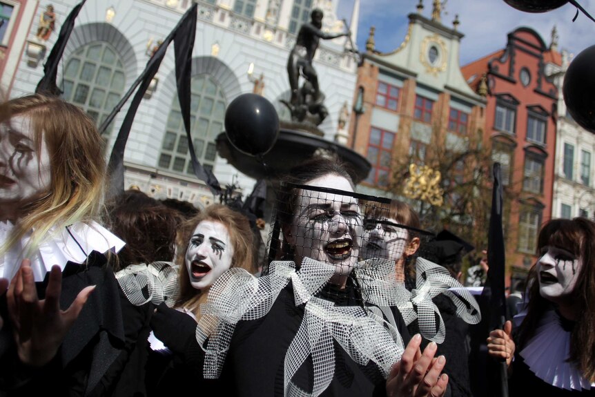 Costumed mourners march on the streets in Gdansk, Poland.