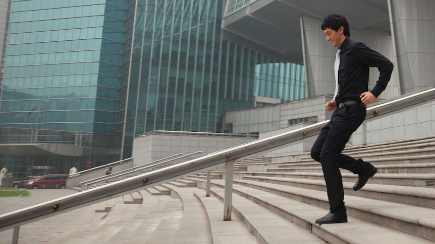 Man in suit running down stairs outside