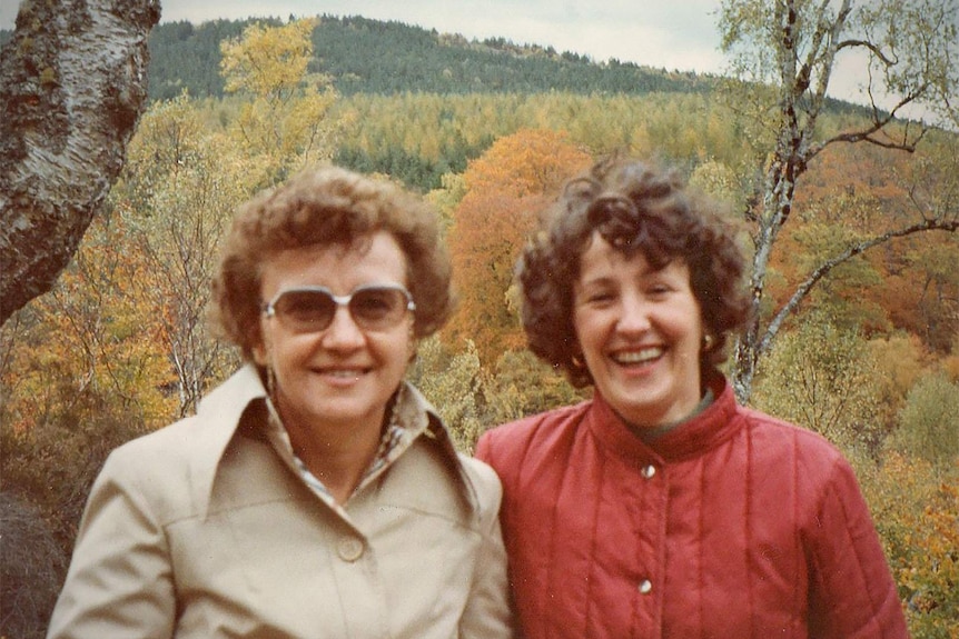 Jill Stretton and her friend Cathie Alexander wear warm coats in front of a rural scene in Scotland