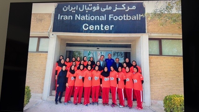 Um time de futebol posa junto do lado de fora "Centro Nacional de Futebol do Irã"
