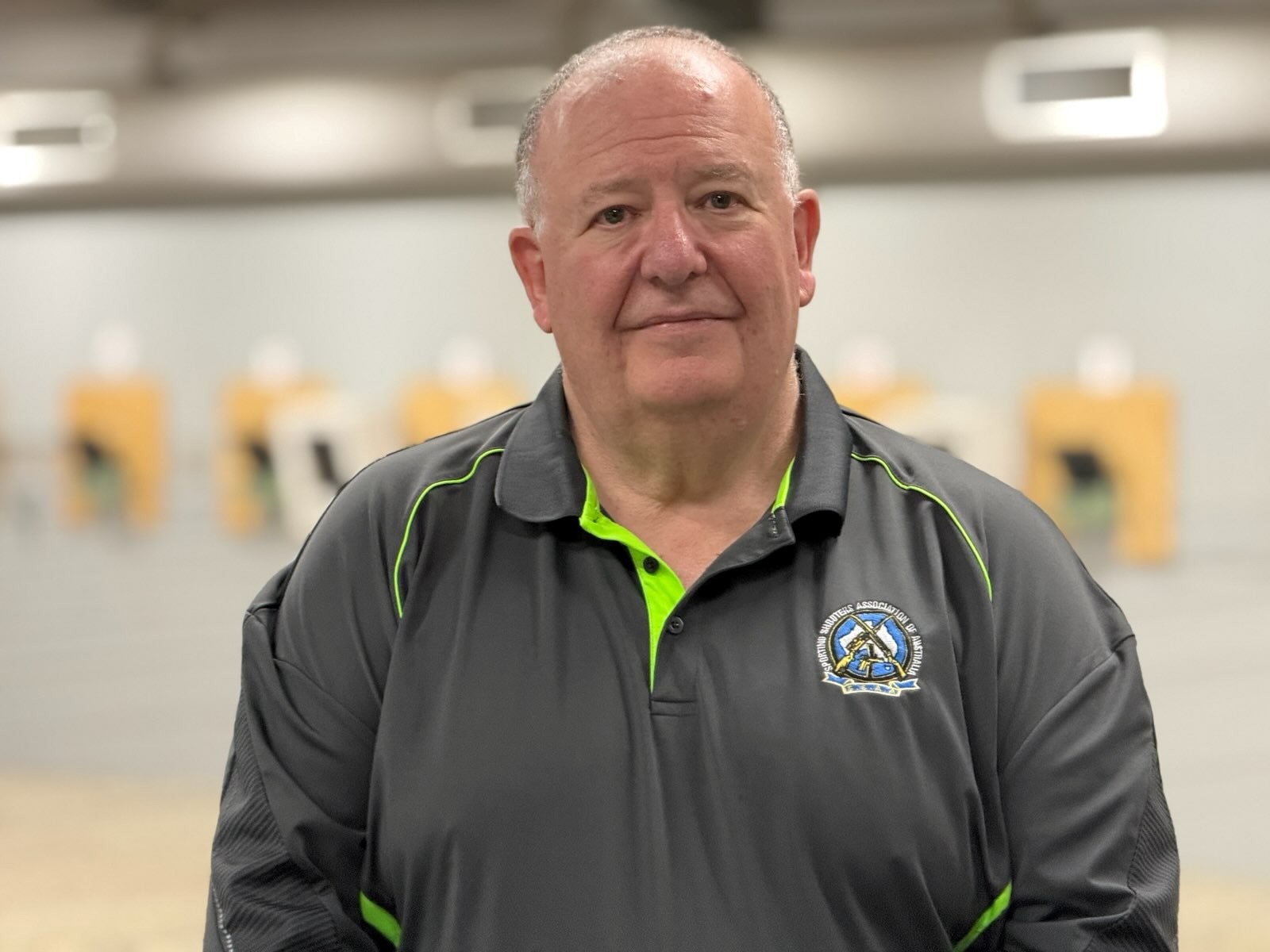 Un hombre vestido con una camisa gris.