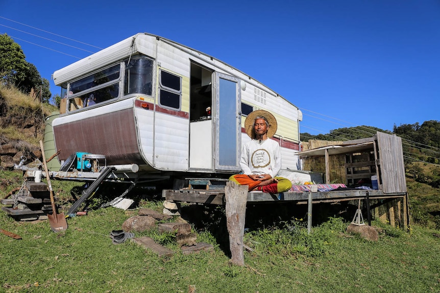 Pairoj Brahma meditating on the deck outside of his caravan