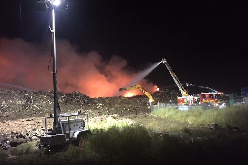 Water is sprayed onto a large fire.