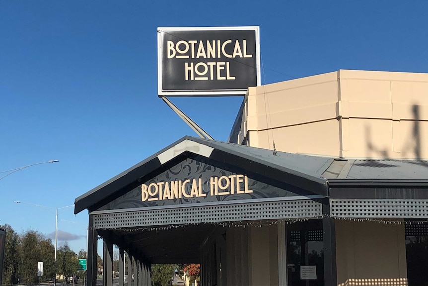 A black sign with the words "Botanical Hotel" written across it in grey lettering.