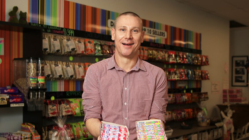 James Byrne holds two boxes of Life Savers in the Darrell Lea shop in Ingleburn.