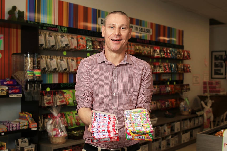 James Byrne holds two boxes of Life Savers in the Darrell Lea shop in Ingleburn.