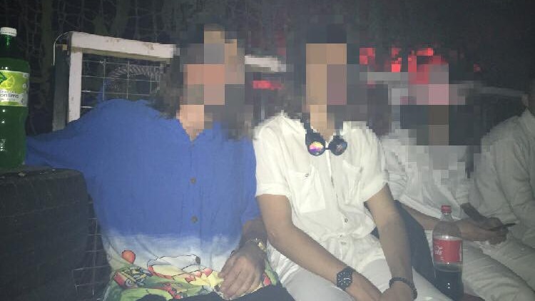 Three men sitting with their faces blurred.