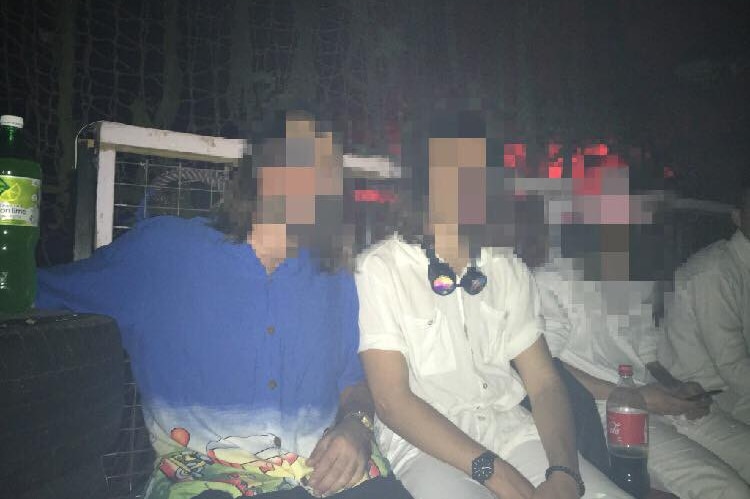 Three men sitting with their faces blurred.