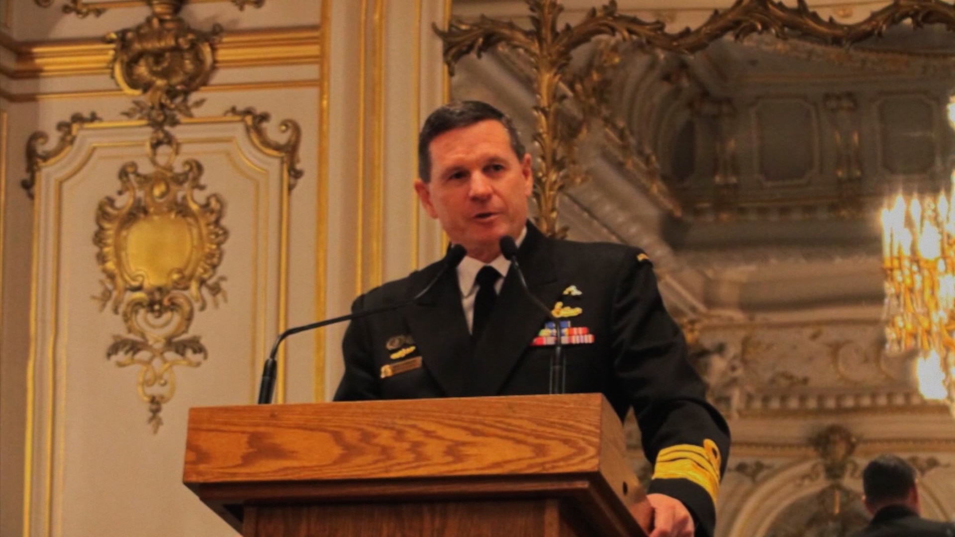 A defence chief wearing military uniform speaking at a lectern in a ballroom.