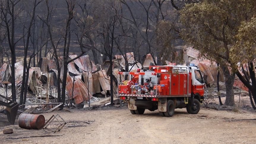 A fire engine in front of a burnt-out Carwoola property