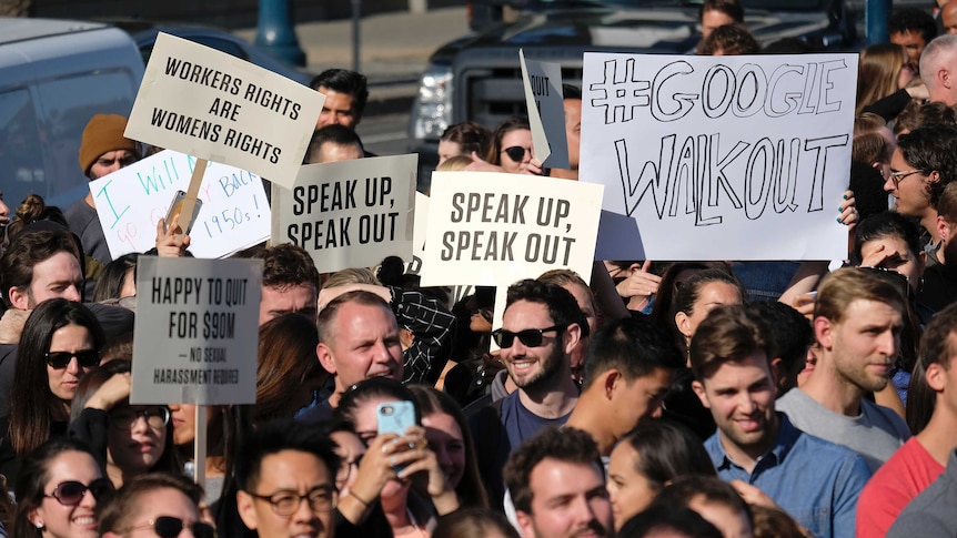 Google employees hold up signs saying 'Speak Up, Speak Out' in San Francisco.