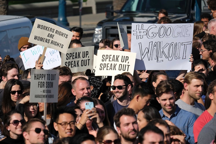 Google employees hold up signs saying 'Speak Up, Speak Out' in San Francisco.