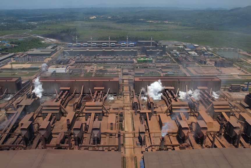 An aerial view of a factory complex during the day.