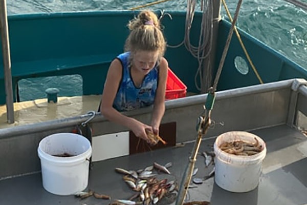 Year 7 Mareeba student Kealey Rose helps on her father's fishing trawler off the coast of far north Queensland.