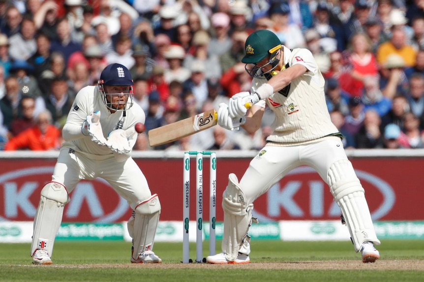 Marnus Labuschagne leans back and plays a cut shot with a horizontal bat as Jonny Bairstow crouches behind him with gloves ready