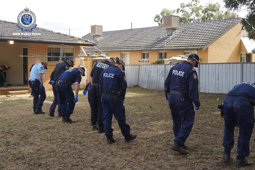 Photo of police conducting a search in a backyard