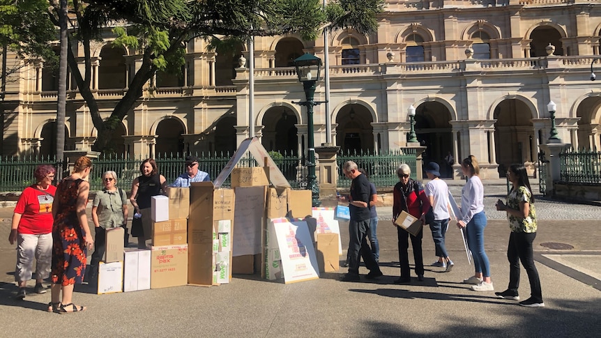 Protesters stand outside Parlaiment House in Brisbane.