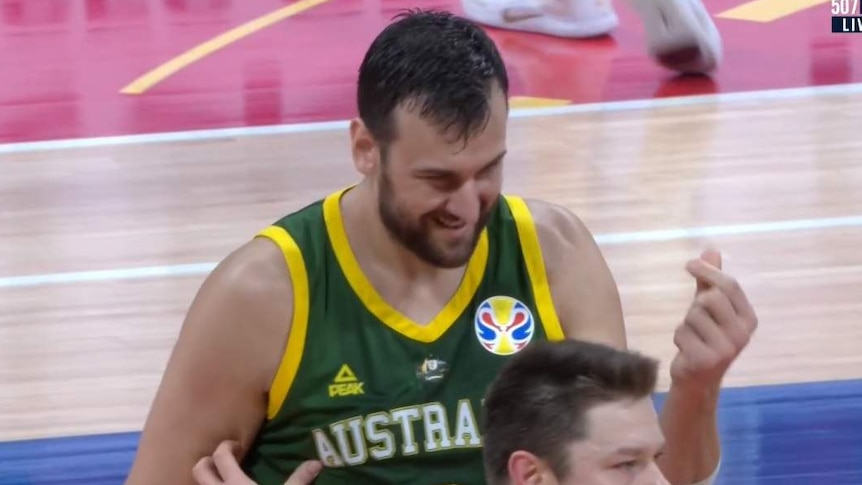 Andrew Bogut rubs his fingers together with his left hand