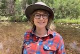 Woman wearing hat and glasses in front of lagoon