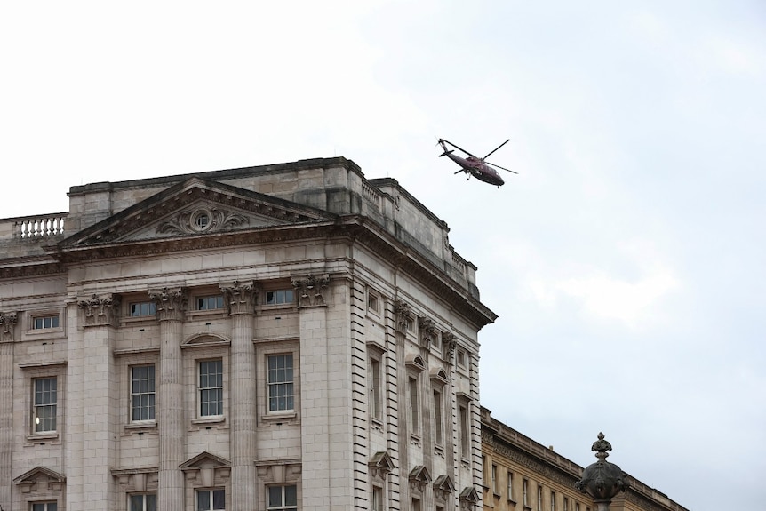 A large building with a helicopter above it, seen from a distance 