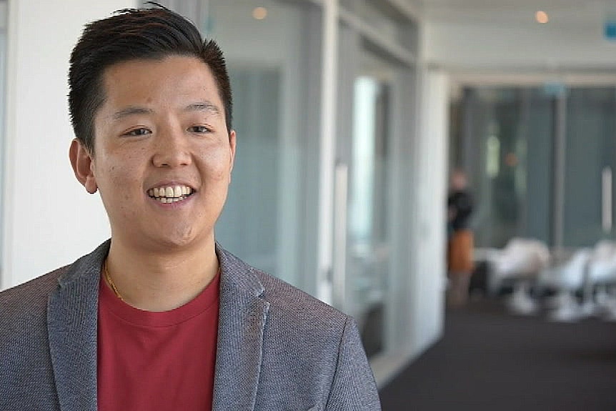 A man smiles at the camera in an office