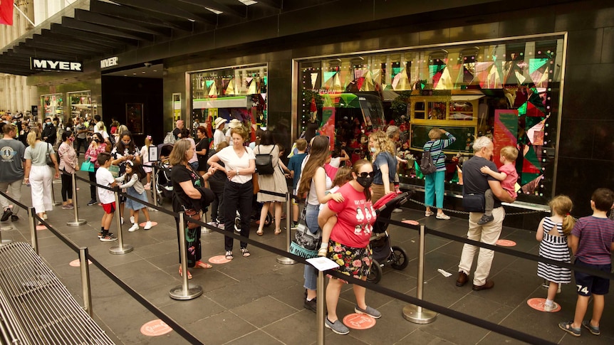 People stand 1.5 metres apart in line to see the Myer Christmas window in Melbourne CBD.
