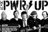 Five members of AC/DC, pose for a photo under the slogan PWR UP. Angus Young is in his schoolboy outfit
