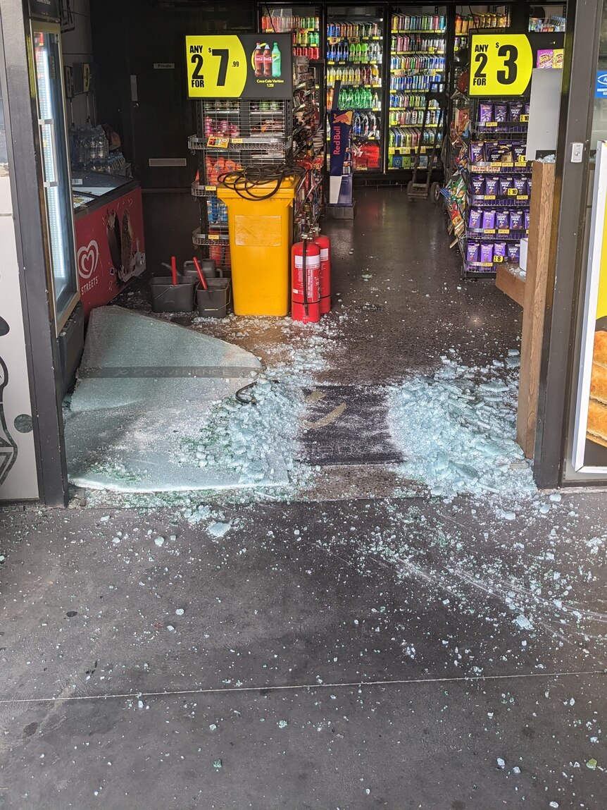 Broken glass scattered over the entrance to a service station