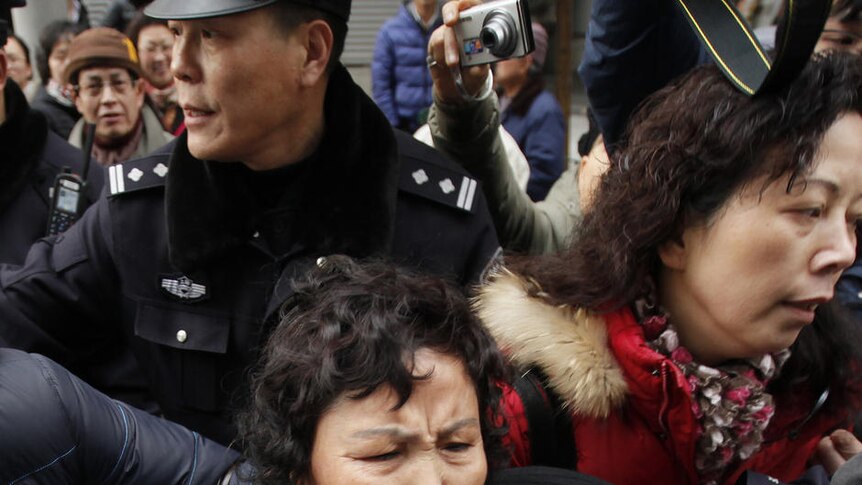 A woman is arrested by police after internet social networks called people to join a "Jasmine Revolution" protest
