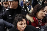 A woman is arrested by police after internet social networks called people to join a "Jasmine Revolution" protest